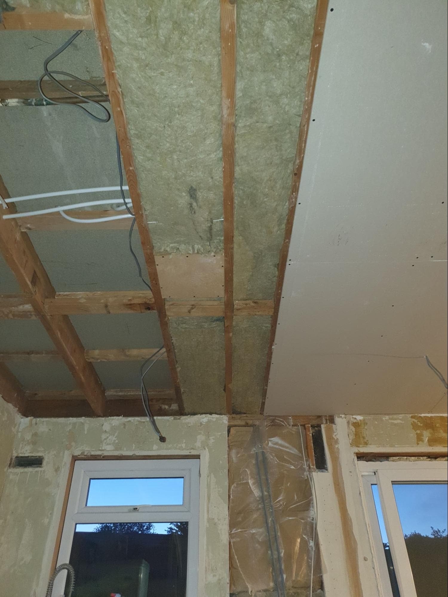 Another view from the kitchen showing a speaker enclosure now surrounded by sound insulation. The holes to install the speaker would be cut after being over-boarded with plasterboard and required careful measure in order to find once it had been covered up.
