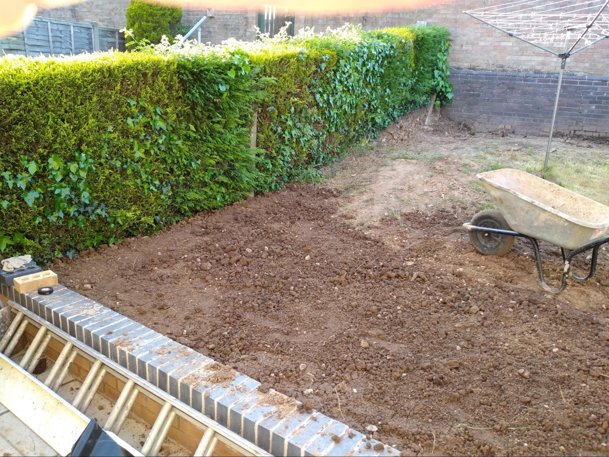 In order to level this very sloped garden, I built a retaining wall with soakaway to a nearby drain and dug a lot of the dirt from the rear, higher part of the garden and moved it to the lower, front section. 